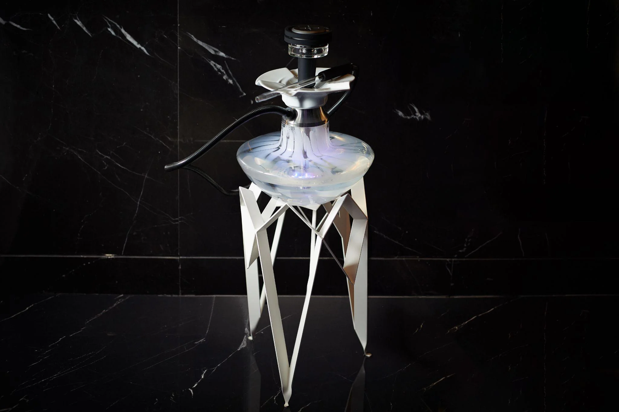 A silver shisha on a black floor